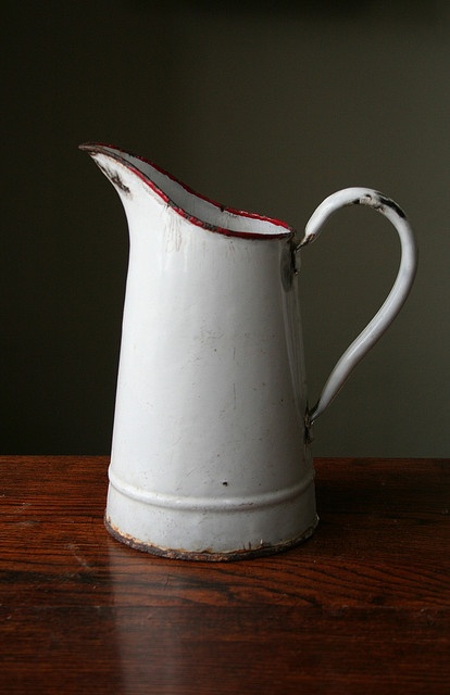 a white pitcher sitting on top of a wooden table