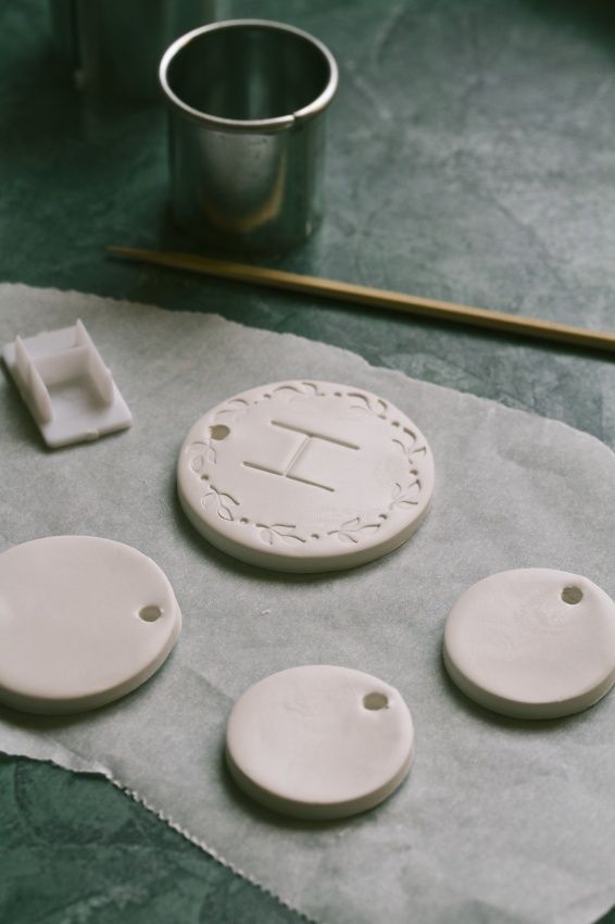 four white ceramic coasters sitting on top of a piece of paper next to a cup