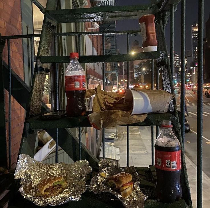 some food is sitting on top of a metal rack near a street corner at night