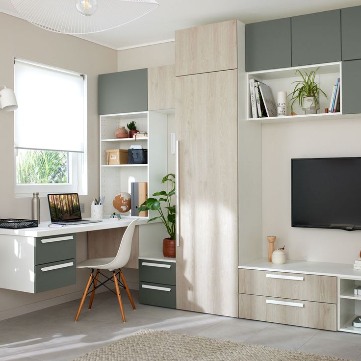 a room with a desk, shelves and a television on the wall next to it