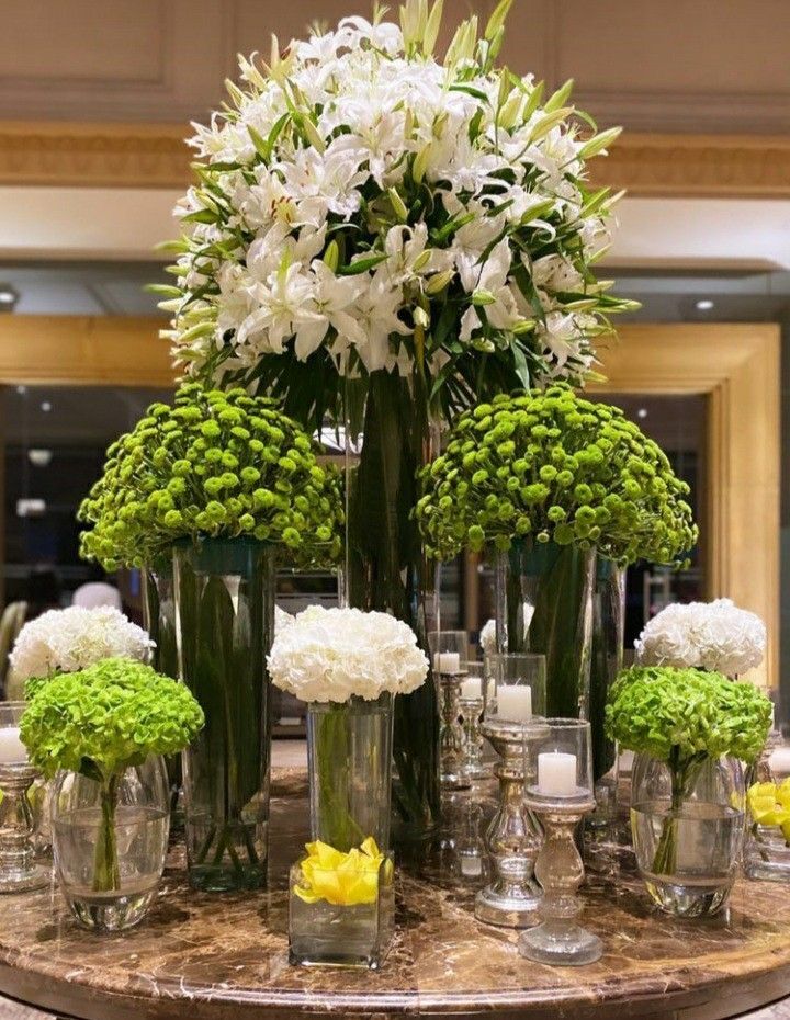 a table topped with lots of vases filled with flowers