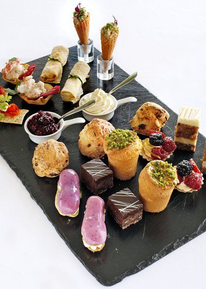 an assortment of desserts and pastries on a slate platter