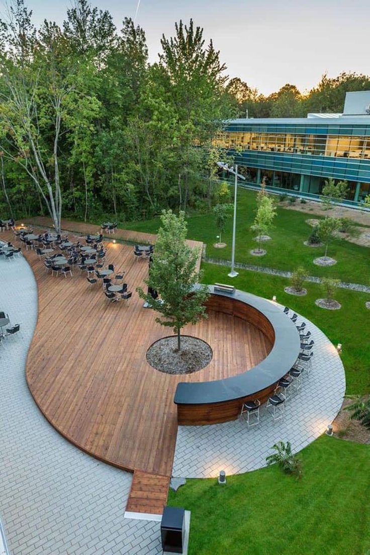 an aerial view of a park with benches and tables in the center, surrounded by green grass