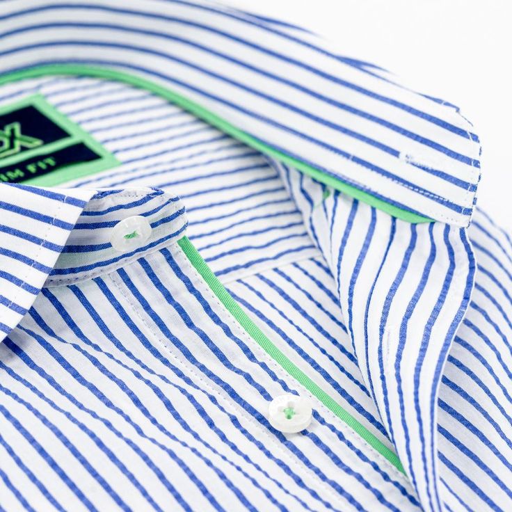 Folded short-sleeve, blue-striped seersucker button up with green trim; green, embroidered frog; and white buttons. Shirt Details Men's, Mens Shirt Details, Pinstripe Shirt, Menswear Details, Shirts For Men Designer, Button Ups, Buttoned Shirt, Shirt Designs For Men, Shirt Detail