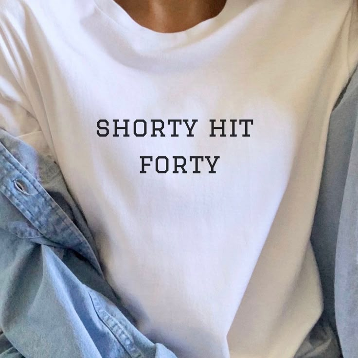 a woman wearing a white shirt that says shorty hit forty