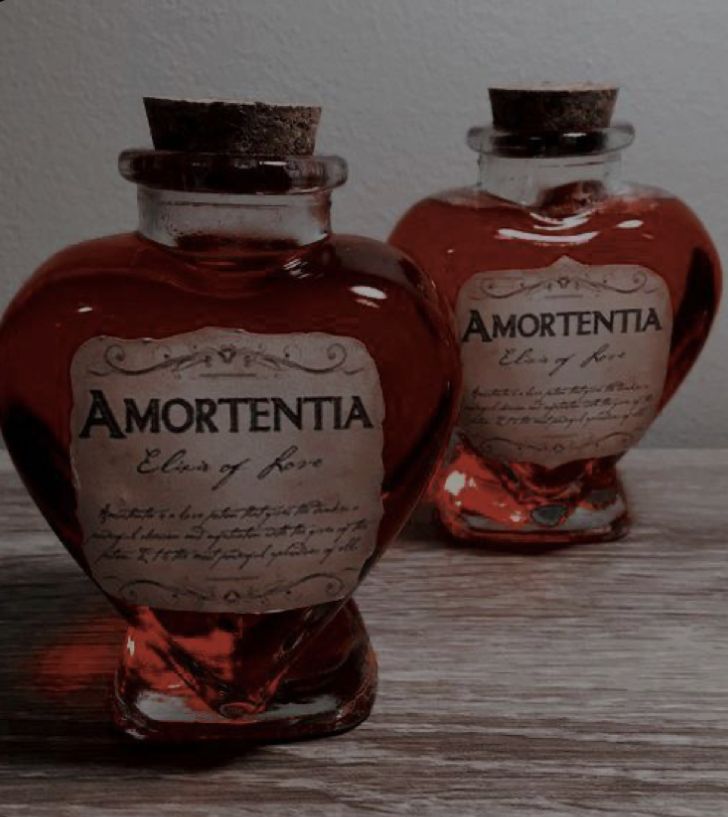 two red glass bottles sitting on top of a wooden table