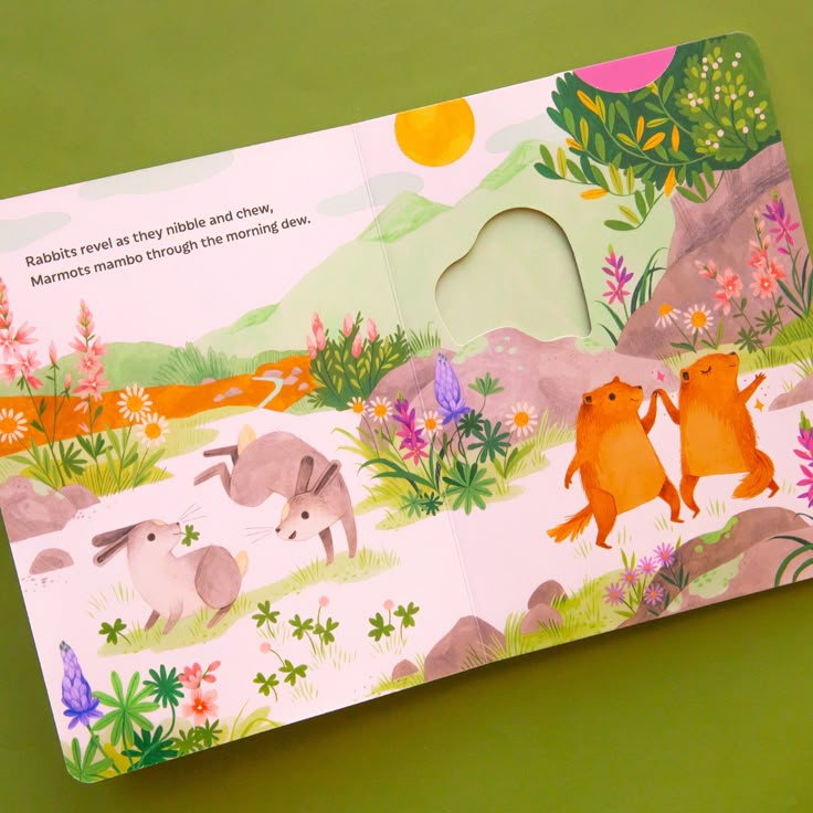 an open children's book with animals and flowers on the cover, sitting on a green surface