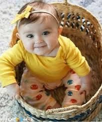 a baby sitting in a basket on the floor