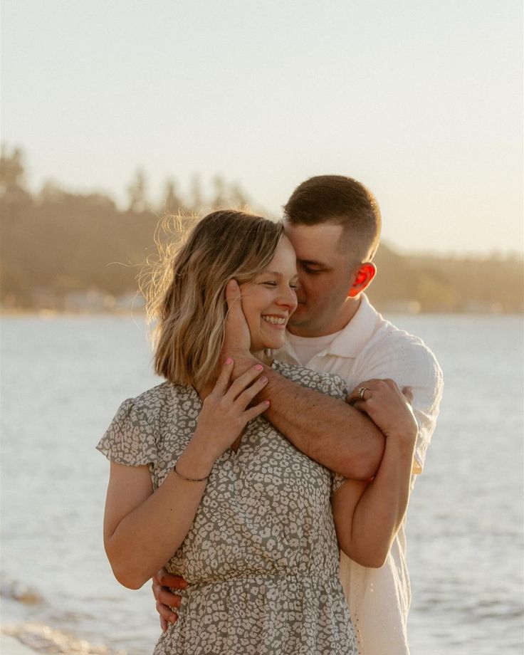 a man and woman embracing each other on the beach