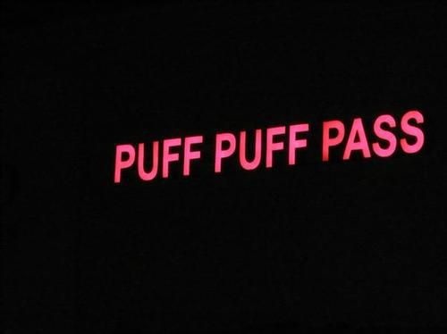 a neon sign that says puff puff pass in red letters on a black background at night