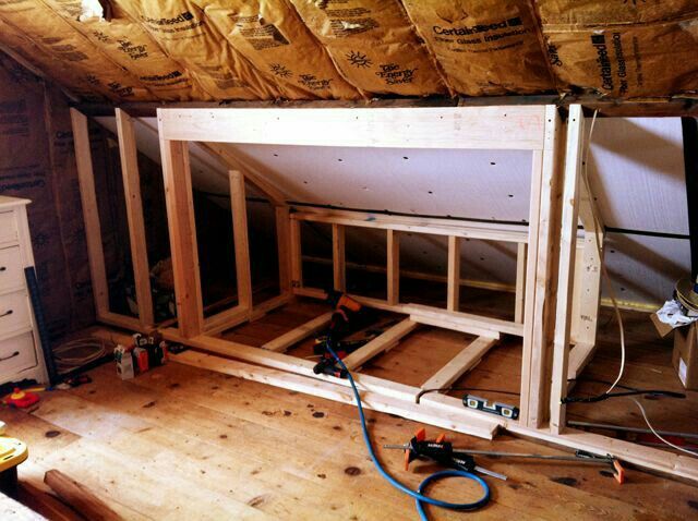 an attic with wood flooring and exposed rafters on the ceiling, under construction