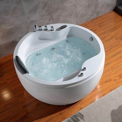 a large white bath tub sitting on top of a wooden floor