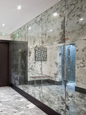 a room with marble walls and flooring in the middle, along with a bench