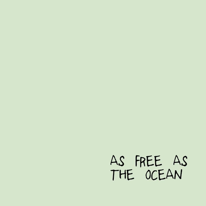 a green wall with the words as free as the ocean written on it in black ink