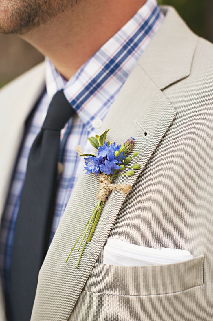 a man wearing a suit and tie with a boutonniere on his lapel