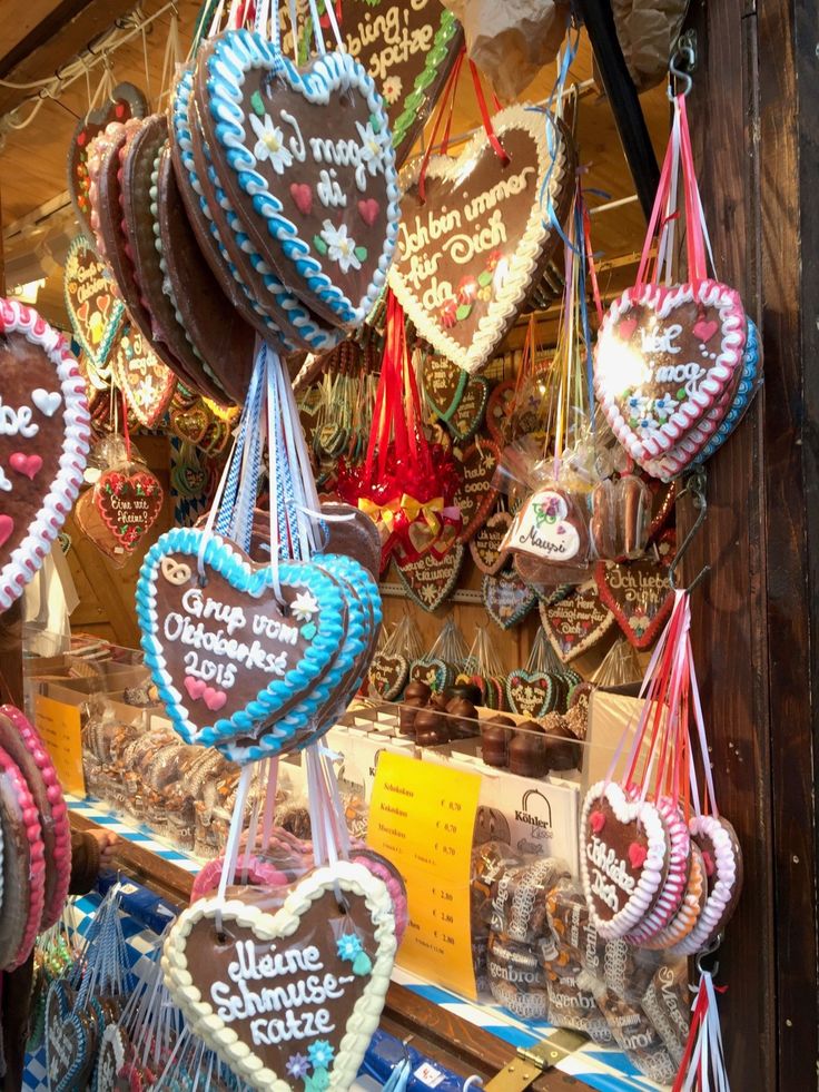 several heart shaped cookies hanging from strings in a store display window with price tags on them