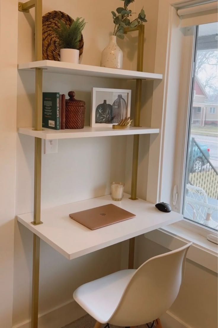 a white desk with some books on it and a chair in front of the window