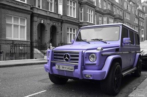 a purple mercedes benz is parked on the side of the road