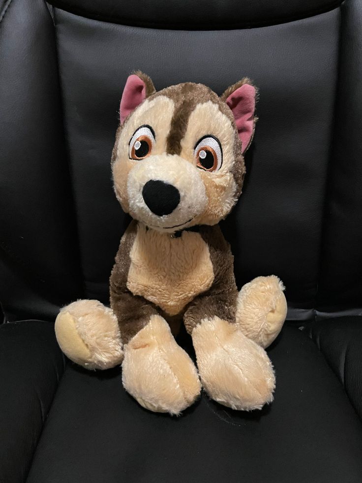 a stuffed animal sitting on top of a black chair