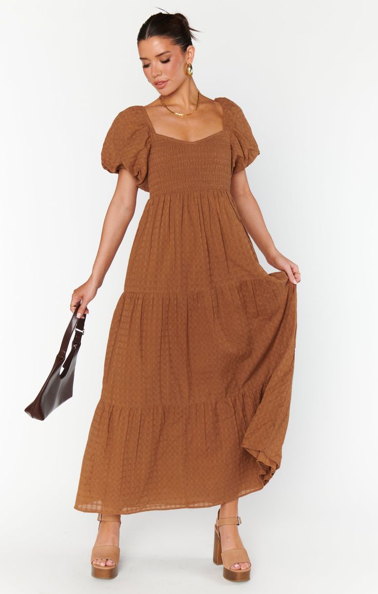 Say hello to your new favorite, the Joanna Midi Dress! Made from lightweight, flowy fabric, it’s perfect for brunch dates and garden parties. With on-trend puff sleeves and a comfy smocked back, this dress has it all. Just add cute sandals and a sun hat, and you're all set for a dreamy picnic in the park! Brown Dress Fall, Maxi Brown Dress, Earth Tone Dresses Casual, Brown Long Dresses, Brown Dress Outfit Fall, Fall Dresses To Wear To A Wedding, Fall Engagement Outfits, Maternity Dress Outfits, Earth Tone Dress