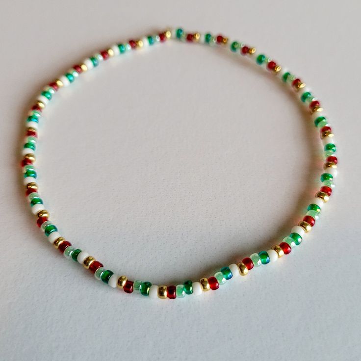 a beaded bracelet with red, green and gold beads