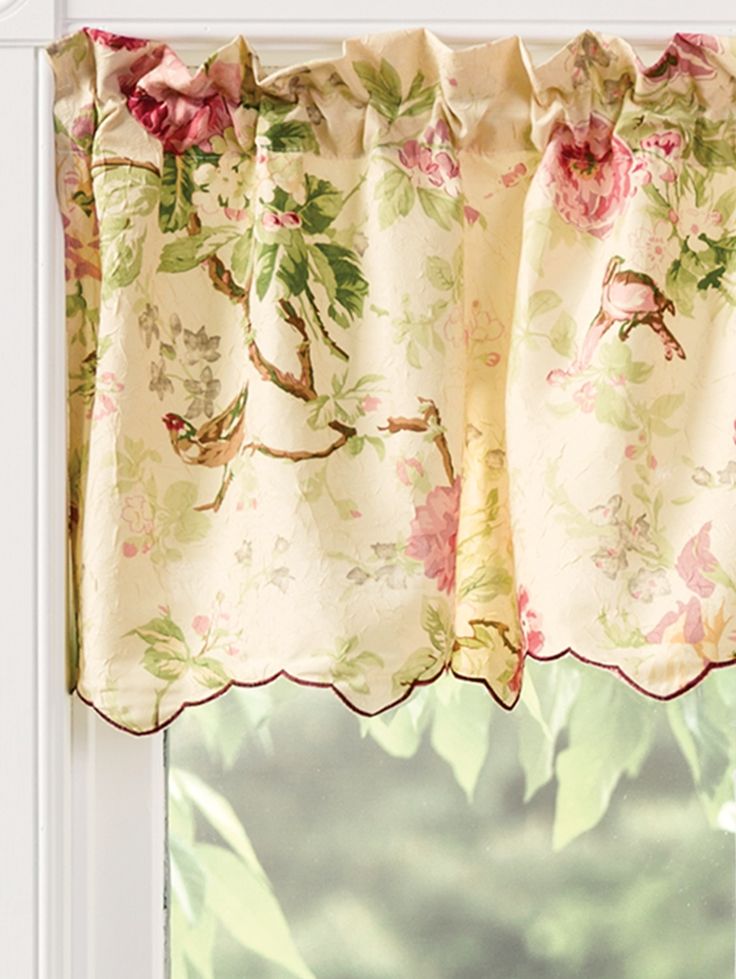 the window is decorated with pink flowers and birds on it's valance,