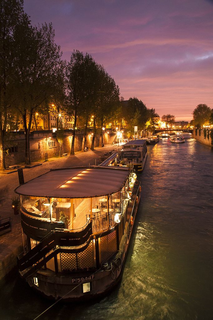 a boat that is sitting on the side of a body of water at night time