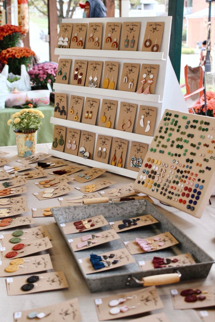 a table topped with lots of different types of earrings on display next to each other