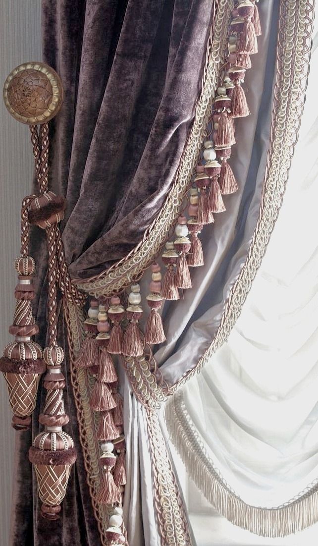 a curtain with tassels hanging from it's side in front of a window