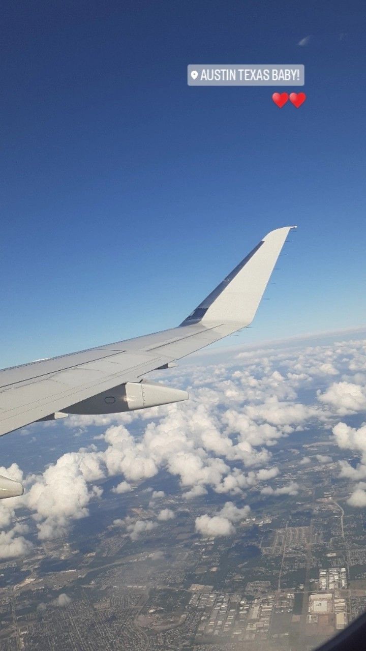 the wing of an airplane as seen from above in the sky with clouds and blue sky