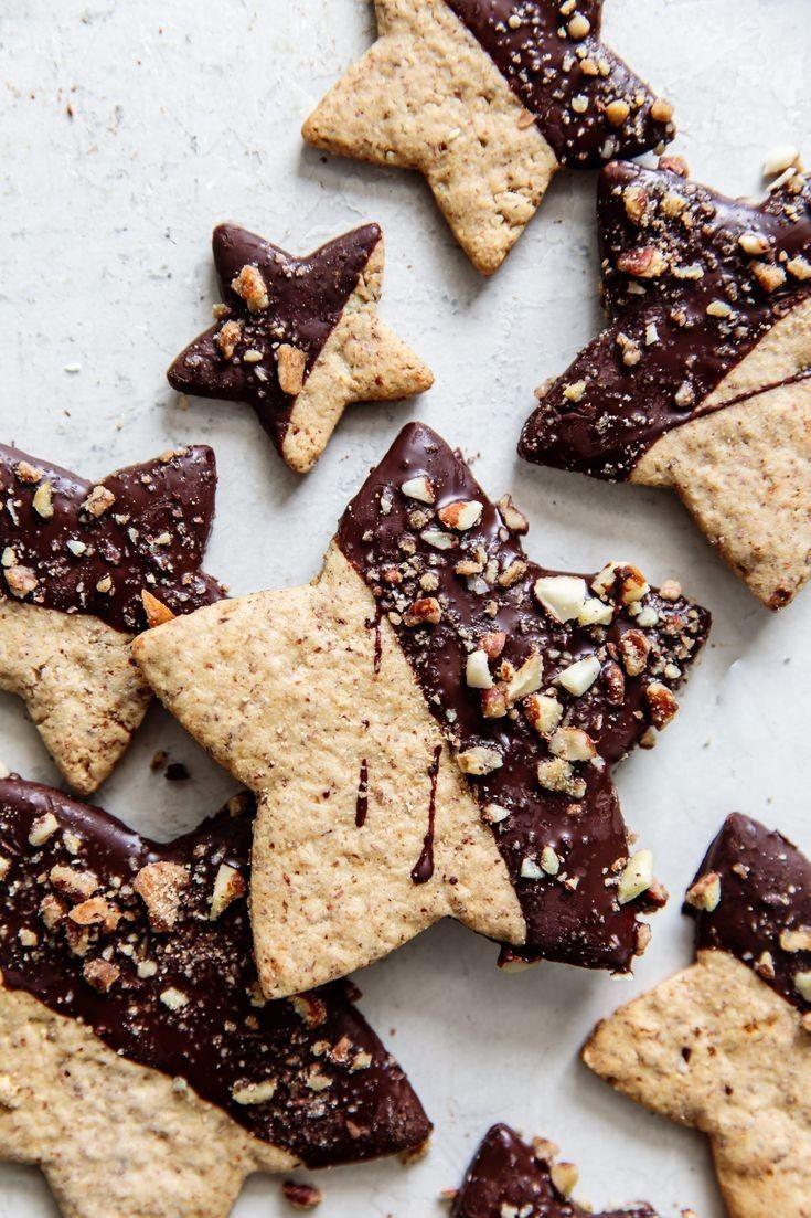 chocolate and almond star cookies on a white surface