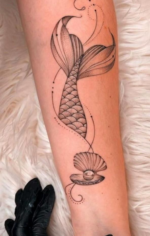 a woman's leg with a fish tattoo on it