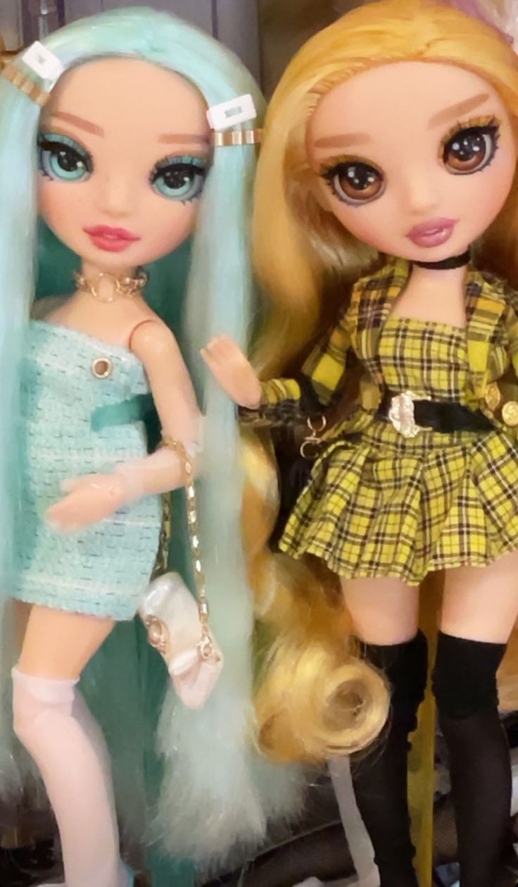 two dolls are standing next to each other