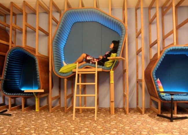 a woman sitting in a chair next to two blue chairs