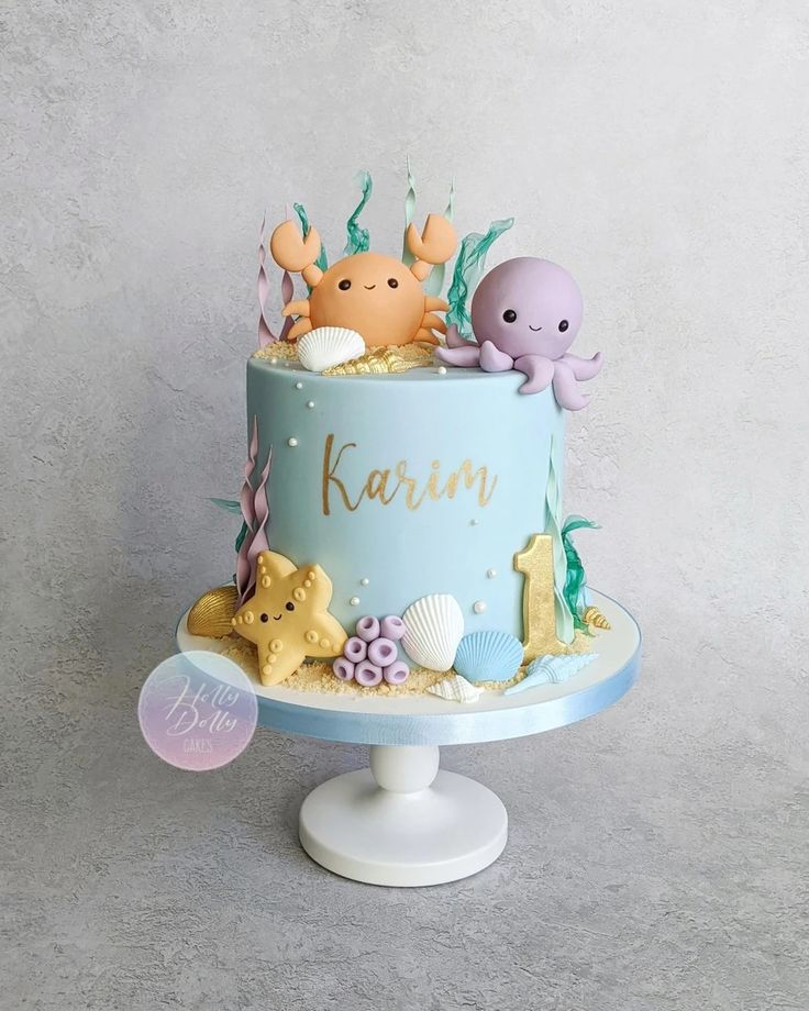 a blue cake decorated with sea animals and under the sea words