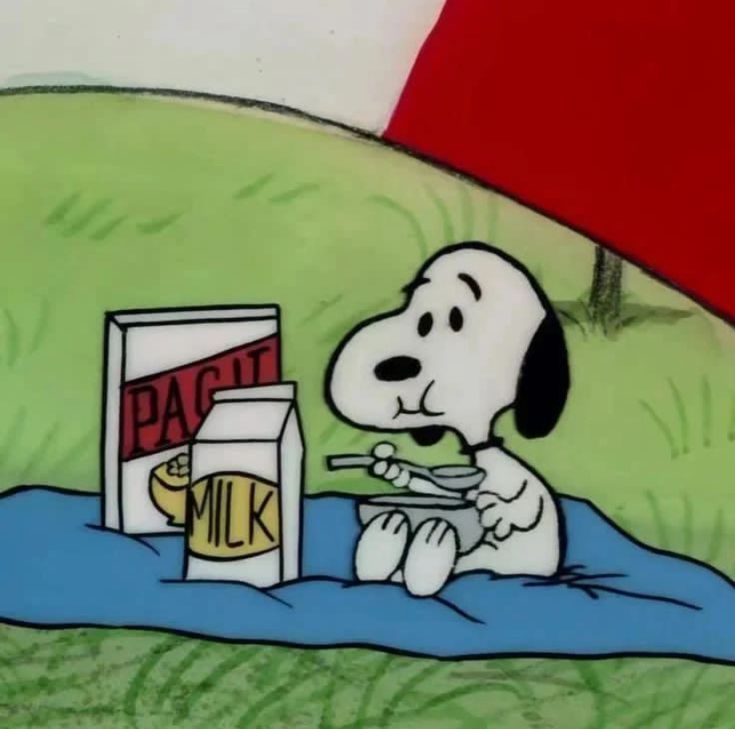 a cartoon dog sitting on top of a blanket next to a carton of milk