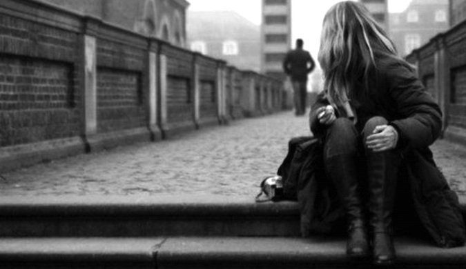 a woman sitting on the ground next to a man