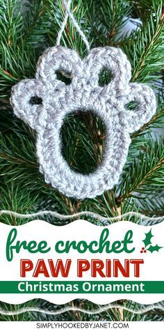 a crocheted christmas ornament hanging from a tree with the words free crochet paw print on it