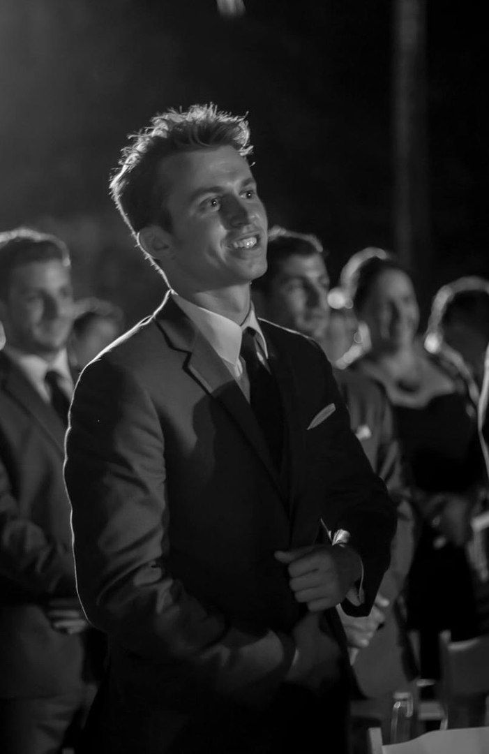 a black and white photo of a man standing in front of a group of people