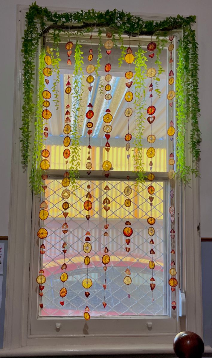 a window decorated with glass beads and greenery