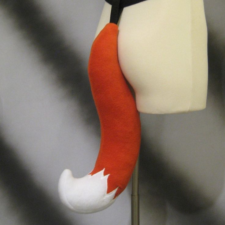 an orange and white stuffed animal hanging from a wall next to a mannequin's head