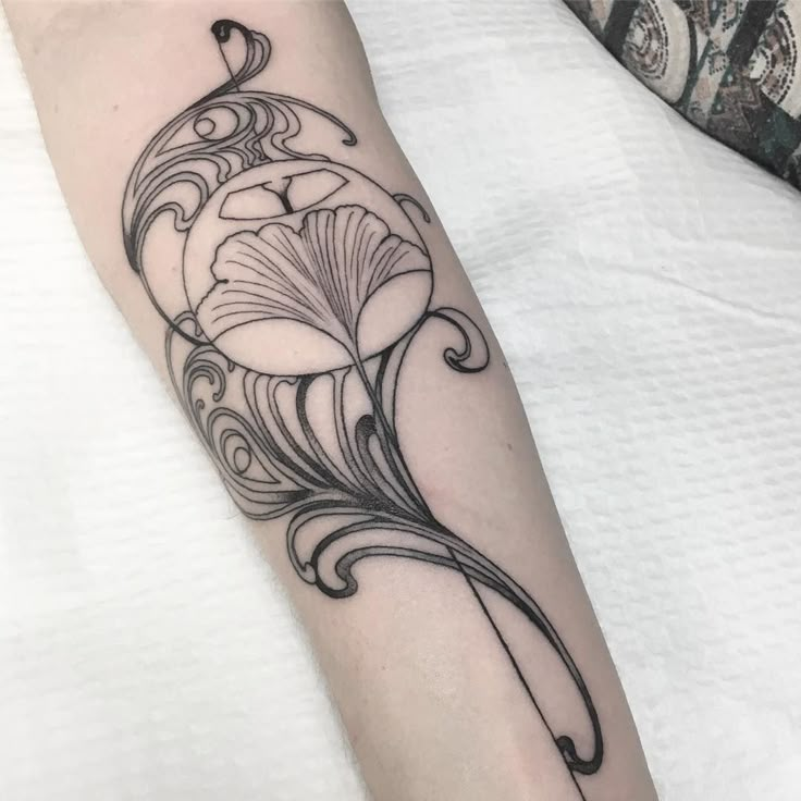 a black and white flower tattoo on the left forearm, with an intricate design in the middle