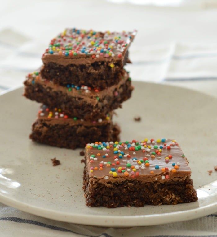 three pieces of chocolate cake with sprinkles on a plate