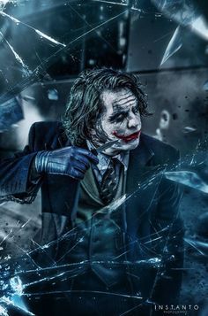 the dark knight movie poster with joker in suit and tie, holding knife up to his face