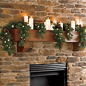 a fireplace decorated with candles and wreaths