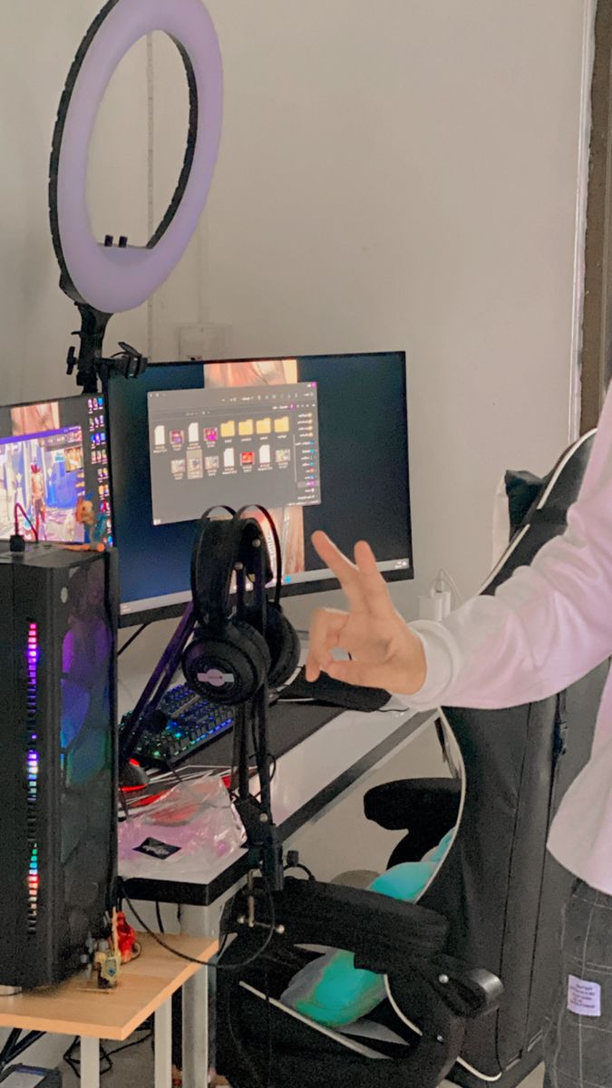 a man sitting in front of a computer monitor on top of a desk next to a chair