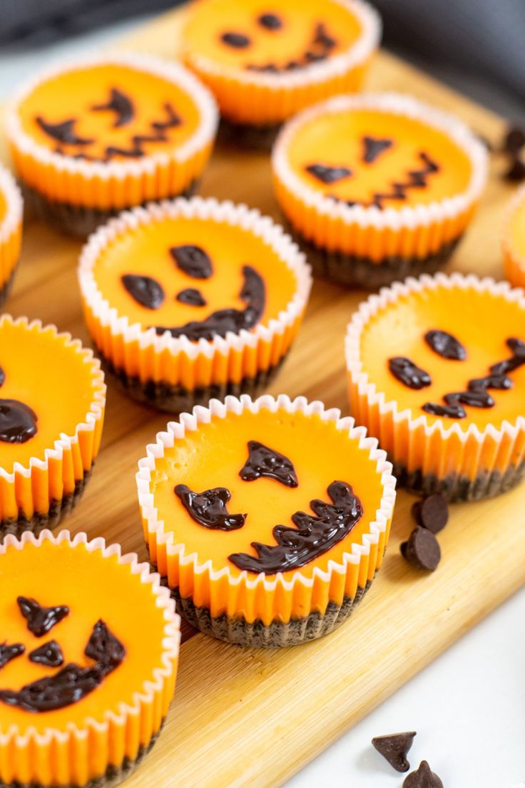 mini halloween cheesecakes on a cutting board with text overlay that reads, mini halloween cheesecakes 40 minutes