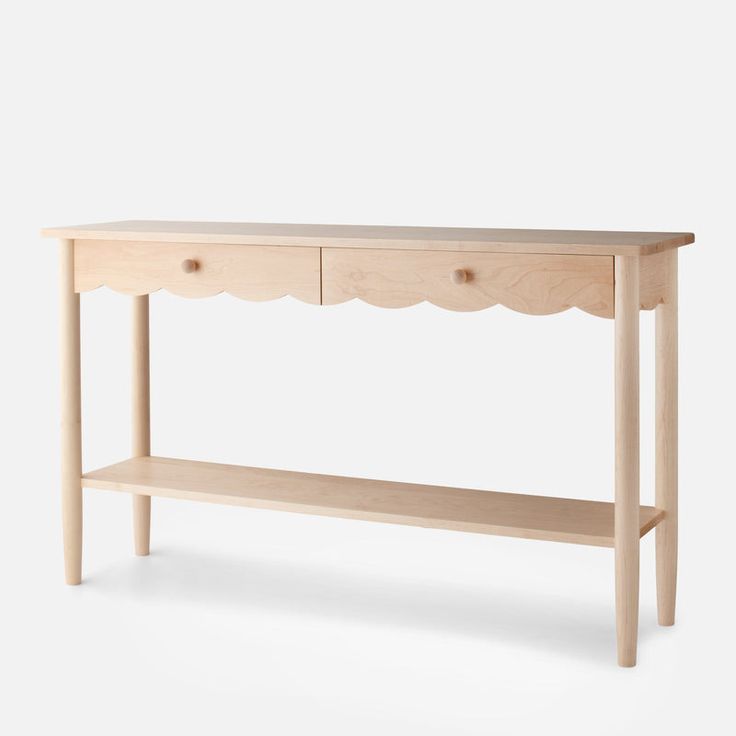 a wooden table with two drawers and a shelf on the bottom that has scalloped edges