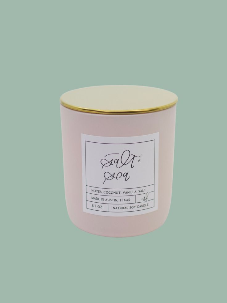 a pink candle with a gold lid and label on it that says, sold out