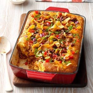 a red casserole dish sitting on top of a wooden table